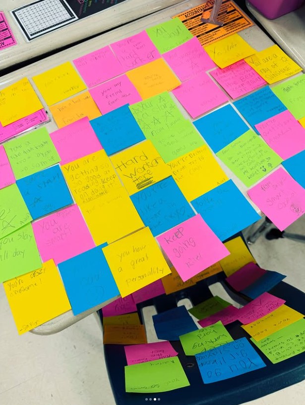 Illustrative photo: Classmates cover a girl's desk in sticky notes of kindness